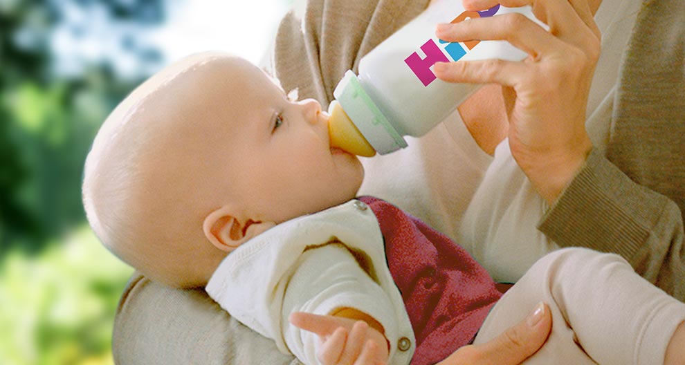A baby is being fed from a bottle.