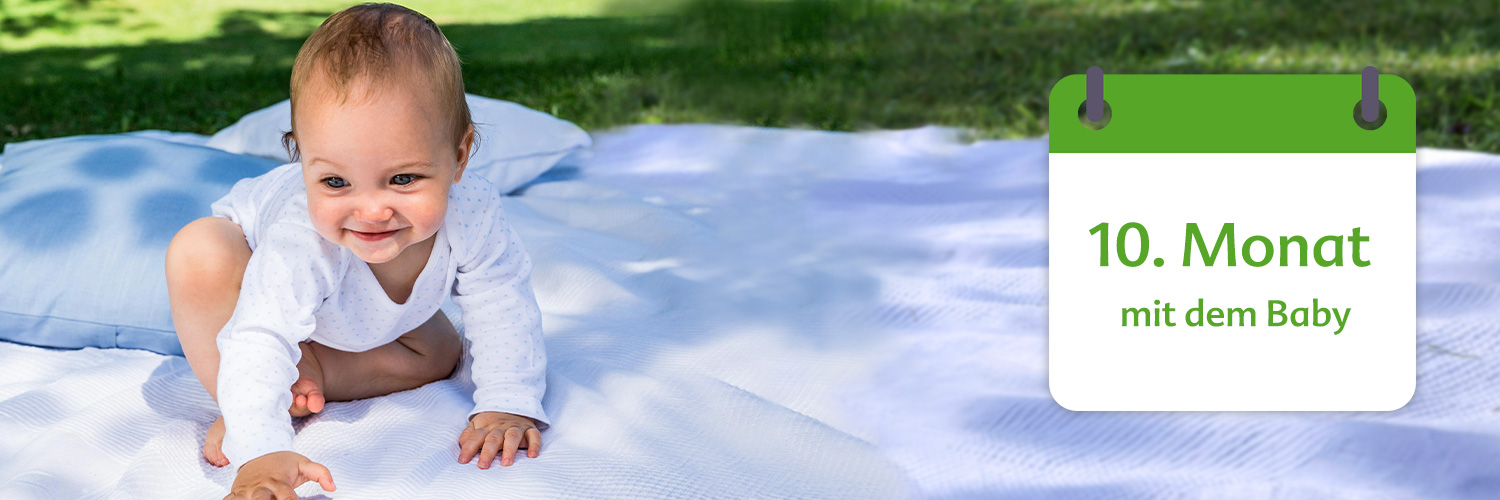A baby sits on a blanket outdoors, next to a calendar indicating the 10th month.