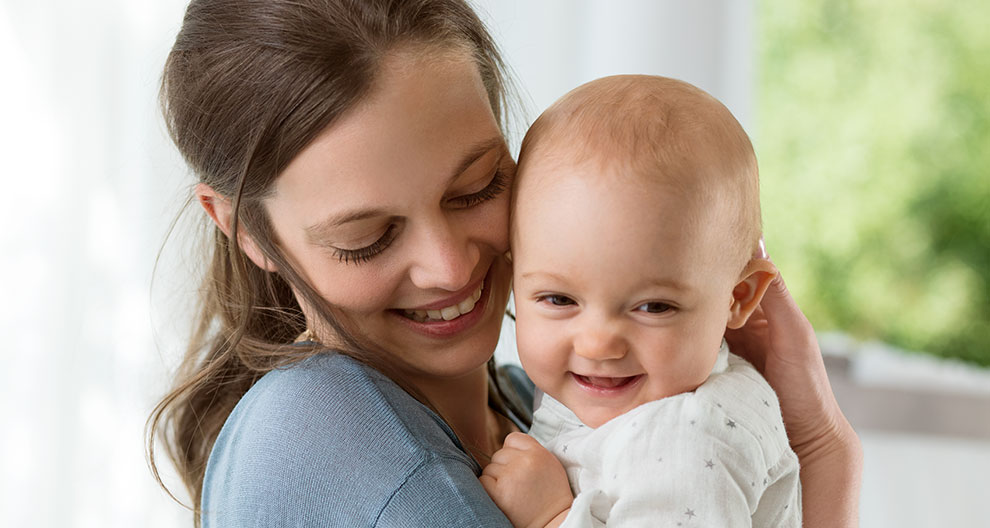 A woman lovingly holds a baby.