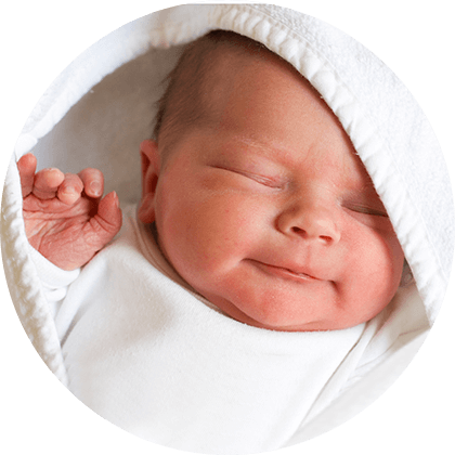 A newborn baby is wrapped in a white cloth, with a hand raised.