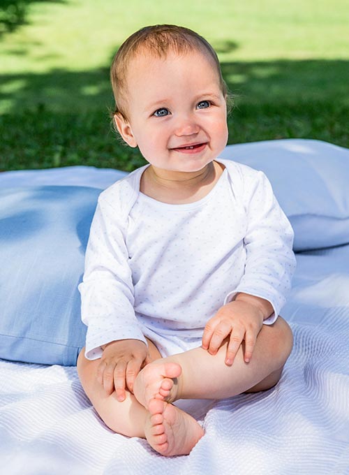 Baby sitting on a blanket.