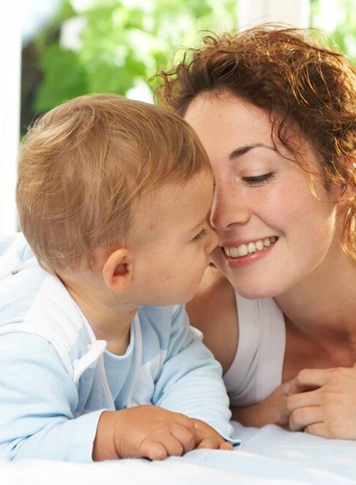 A woman and a baby share a tender moment.