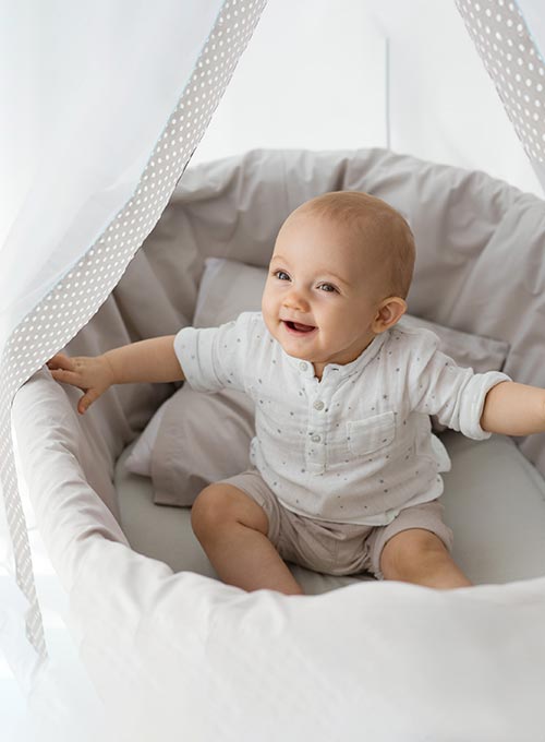 Baby sitting in bassinet.