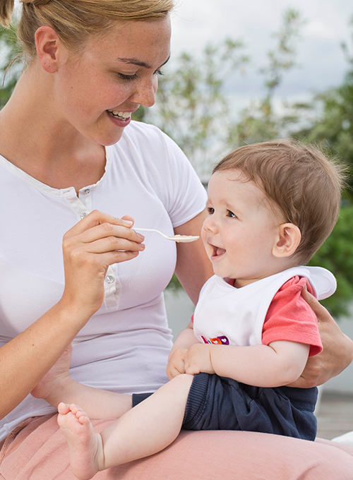 A woman feeds a baby.