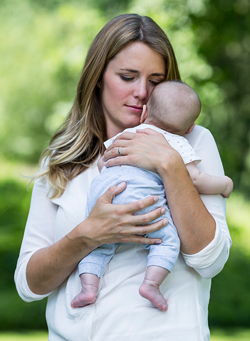 A woman lovingly holds a baby.