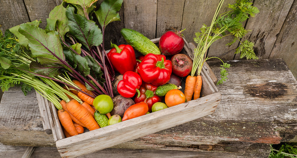 Fresh vegetables in a wooden crate.