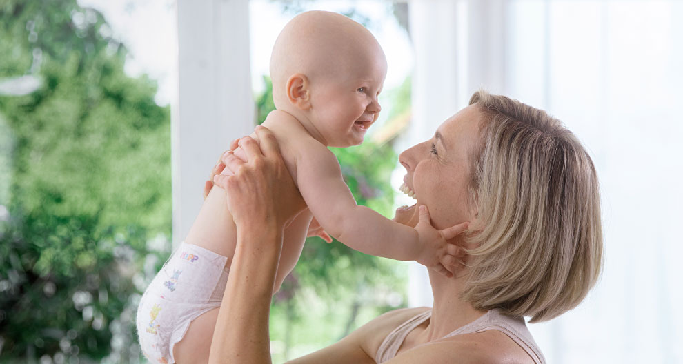 A woman and a baby share a joyful moment.